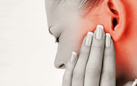 A woman expressing pain due to emporomandibular joint disorder tmd